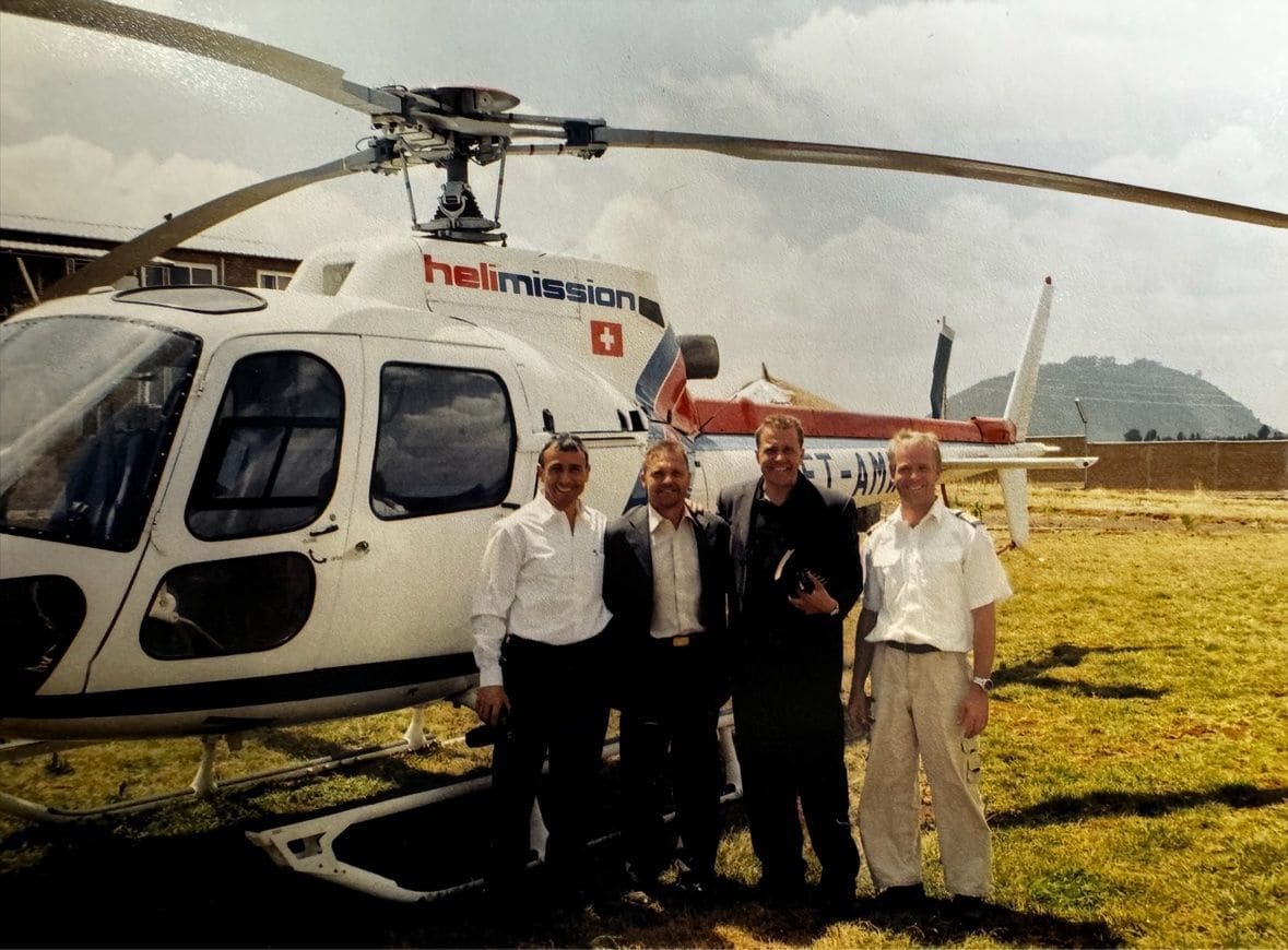 Karl Härgestam and members of the early mission team beside a Heli-Mission helicopter